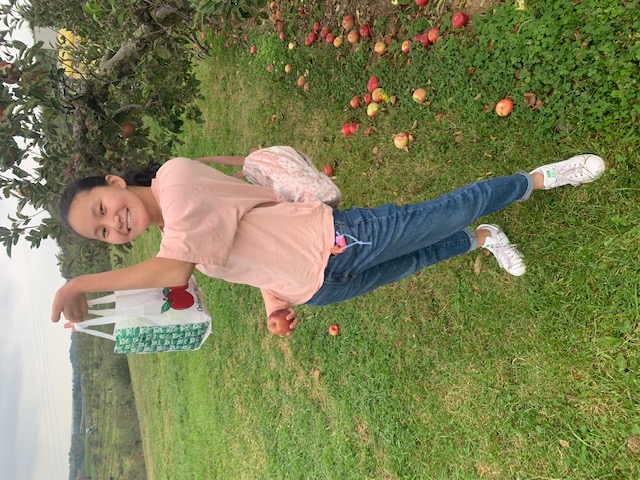 Me holding aloft a bag of apples in an apple orchard